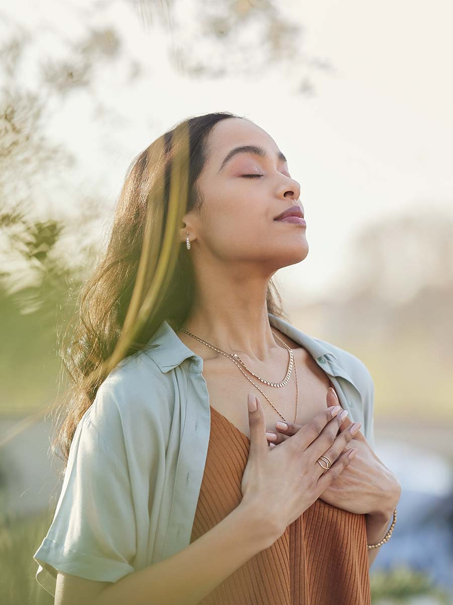 Frau hält sich Hände auf die Brust und entspannt